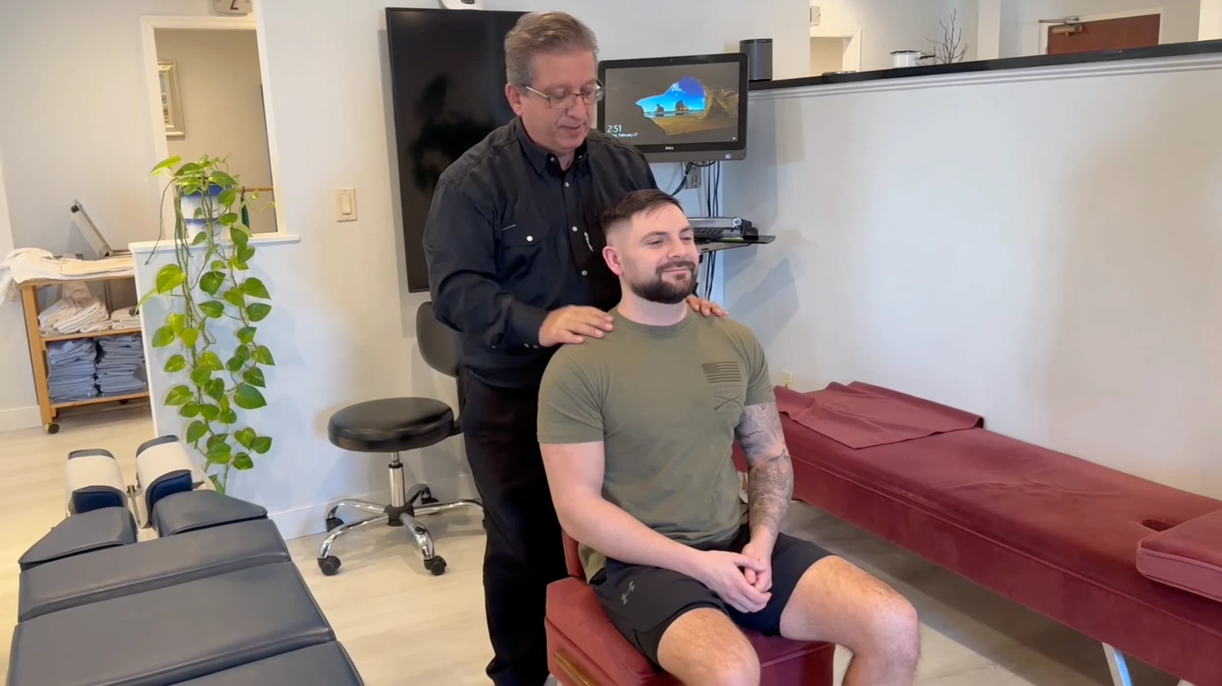Dr. Henry Madalian with his hands resting on a seated patient's shoulders at our Wayne office