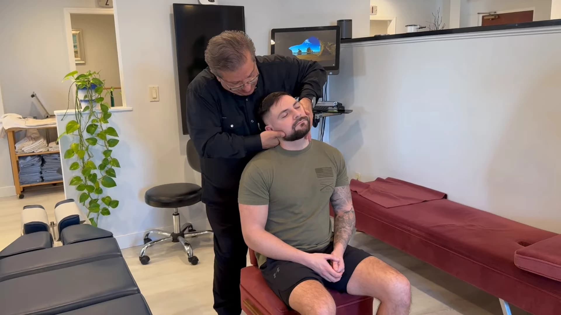 Dr. Henry Madalian providing a seated Gonstead chiropractic adjustment at the Wayne office